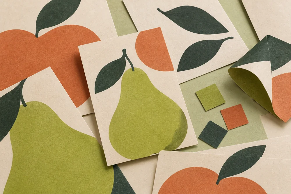 A generated close-up material study of fruit-inspired paper forms, printed sheets and colour samples.